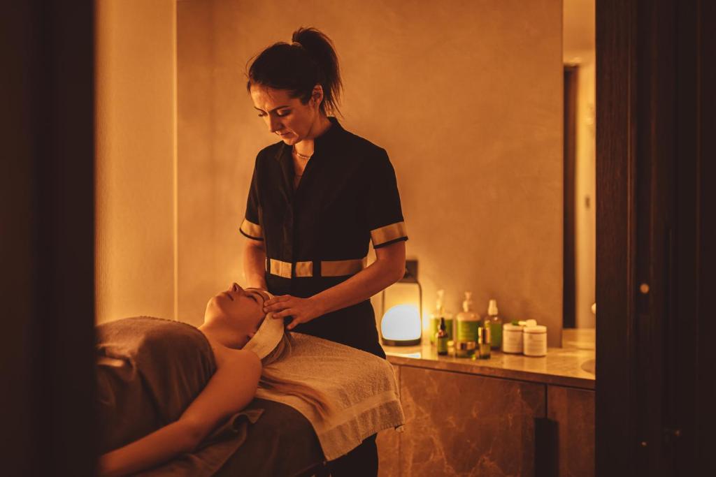 a woman is giving a woman a massage at Coeur de Megève in Megève
