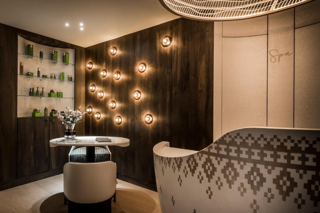 a dining room with a table and a wall with lights at Coeur de Megève in Megève