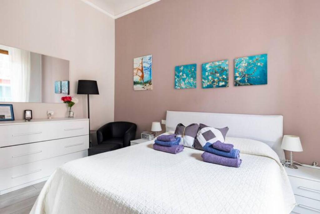 biała sypialnia z białym łóżkiem i krzesłem w obiekcie Big Central Room w mieście La Spezia