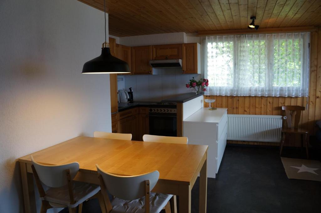 - une cuisine avec une table en bois, des chaises et une cuisinière dans l'établissement Haus Panorama B (Whg. Weibel), à Flumserberg