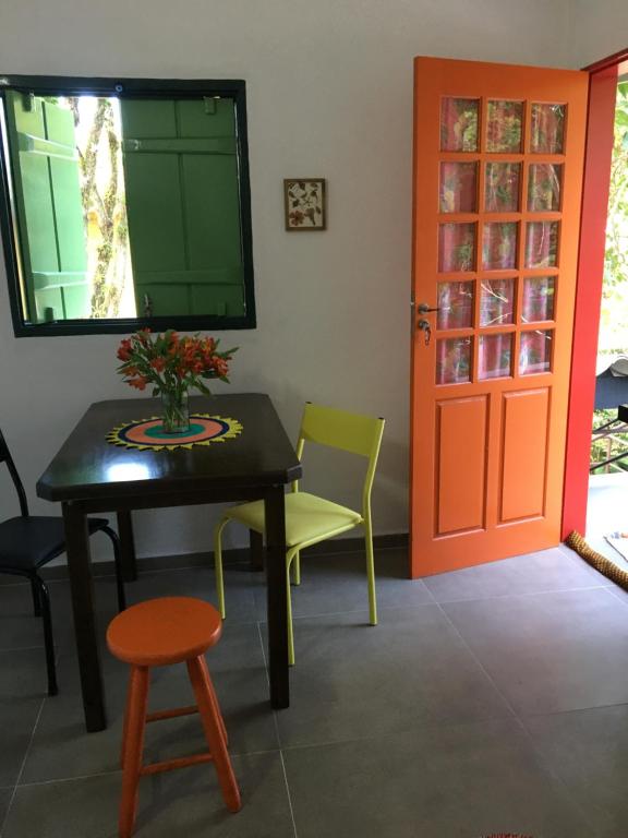 a room with a table and chairs and a door at Casa da árvore in Ubatuba