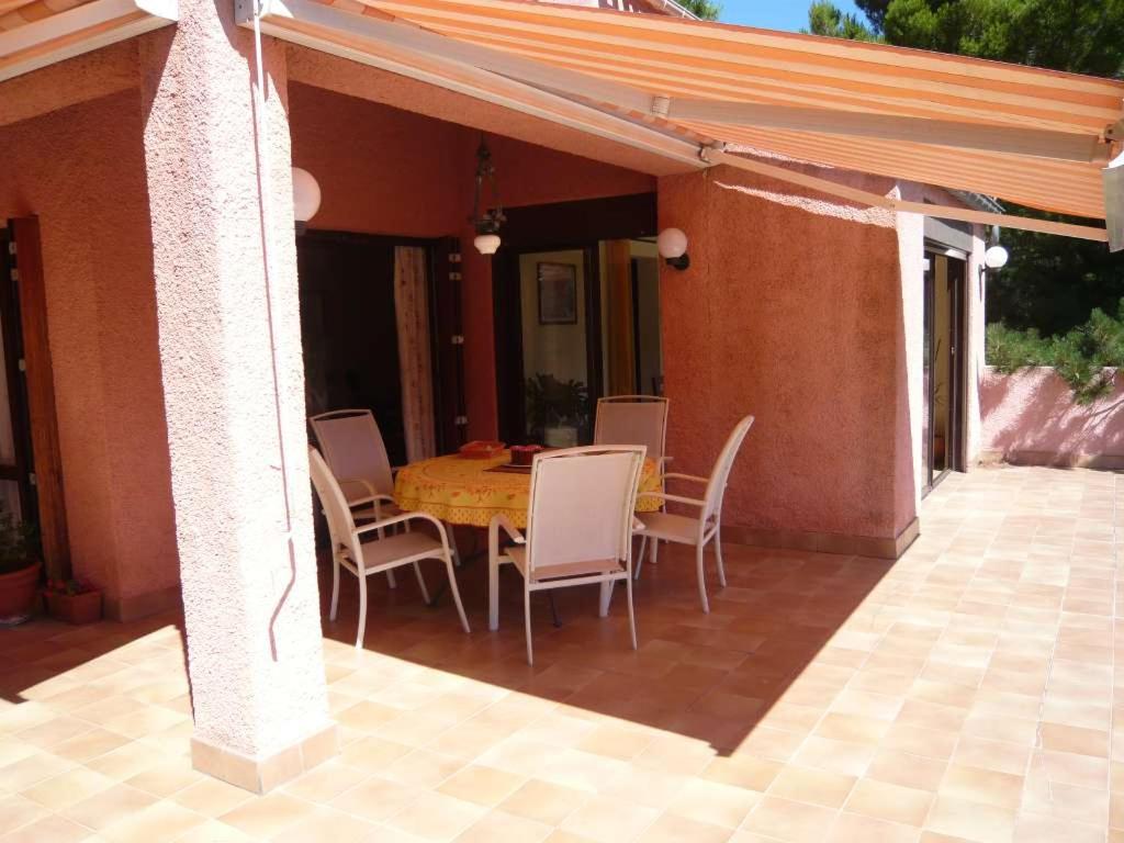 a patio with a table and chairs on a house at Chambres d’hôte l&#39;Amandière à Cucugnan in Cucugnan