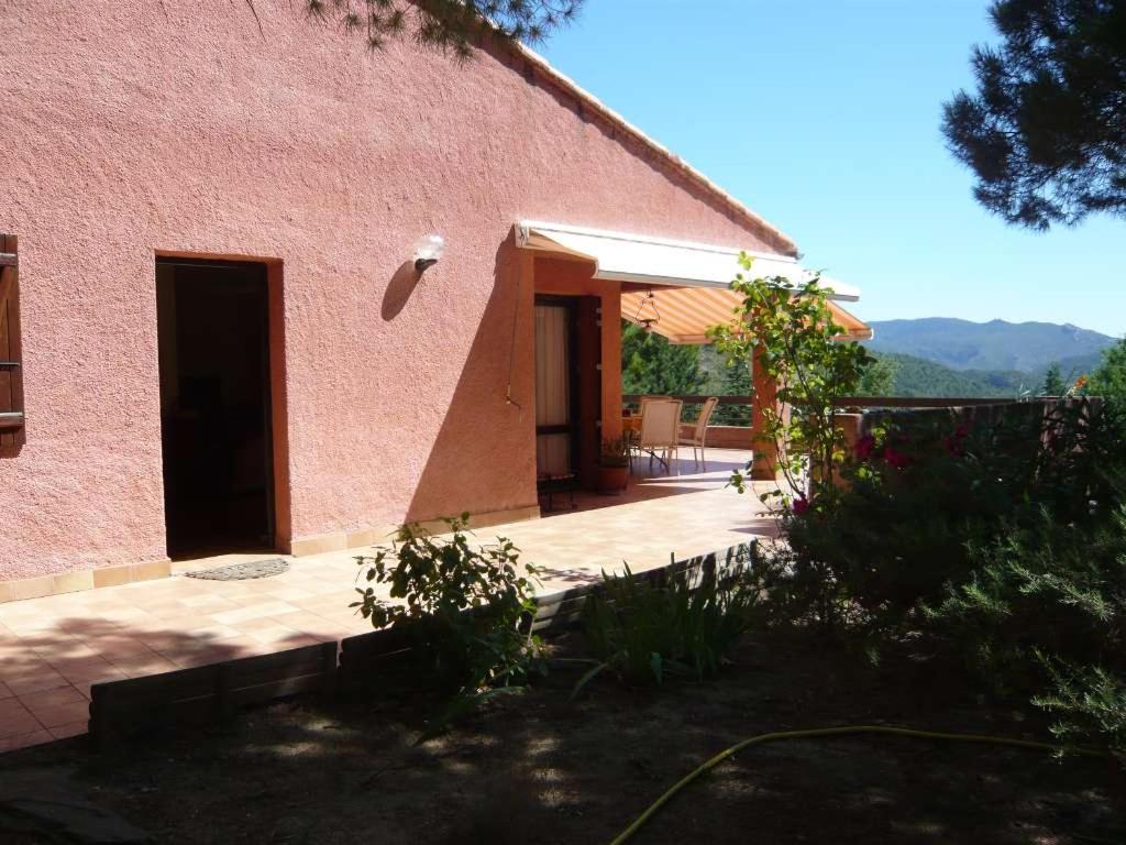 a pink building with a door and a frisbee in the air at Chambres d’hôte l&#39;Amandière à Cucugnan in Cucugnan