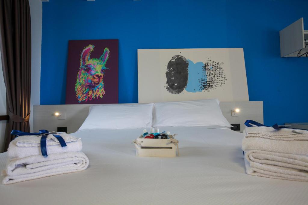 Un dormitorio con una cama blanca con toallas. en Le Tofane, vivi la bellezza di Belluno - Genziana, en Sòis