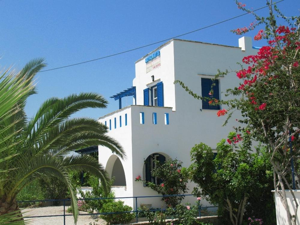 a white building with palm trees in front of it at Mavromatis Studios in Naxos Chora