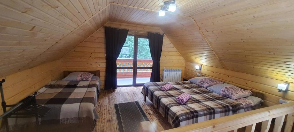 1 Schlafzimmer mit 2 Betten in einem Blockhaus in der Unterkunft Під озером Синевир in Synewyrska Poljana