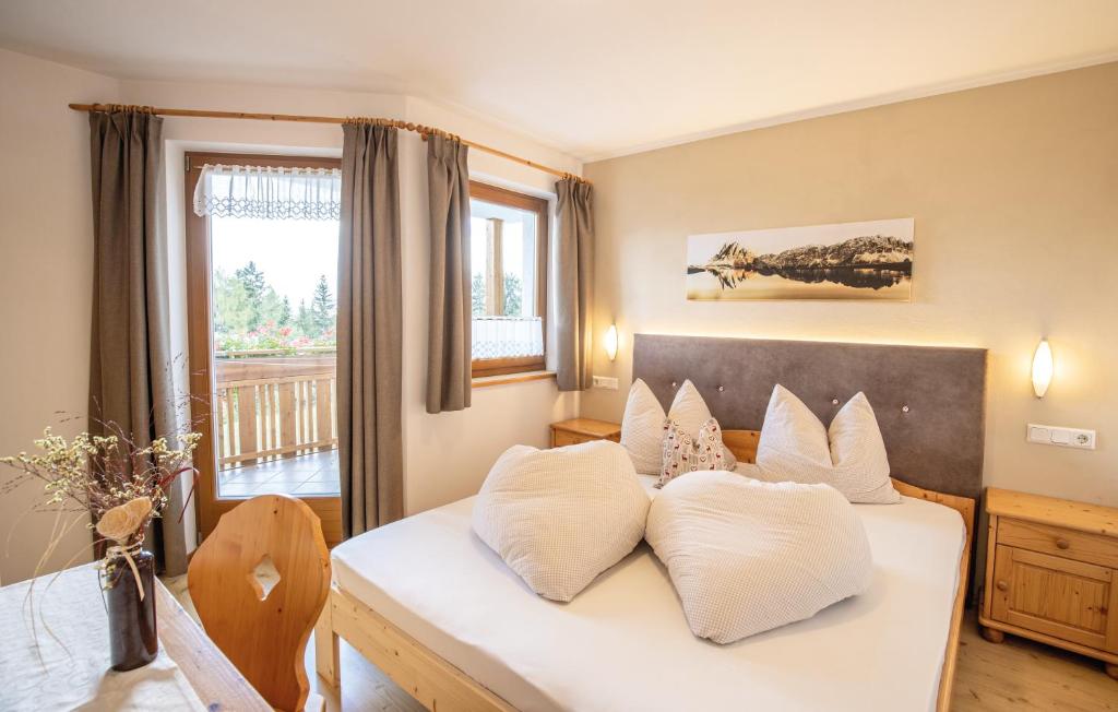 a bedroom with a bed with white pillows at Residence Alpenrose in Bressanone