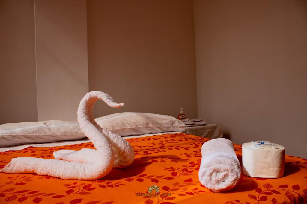 ein Bett mit zwei Schwänen aus Handtüchern in der Unterkunft Hinkiori Inn - Hotel Manu in Pillcopata