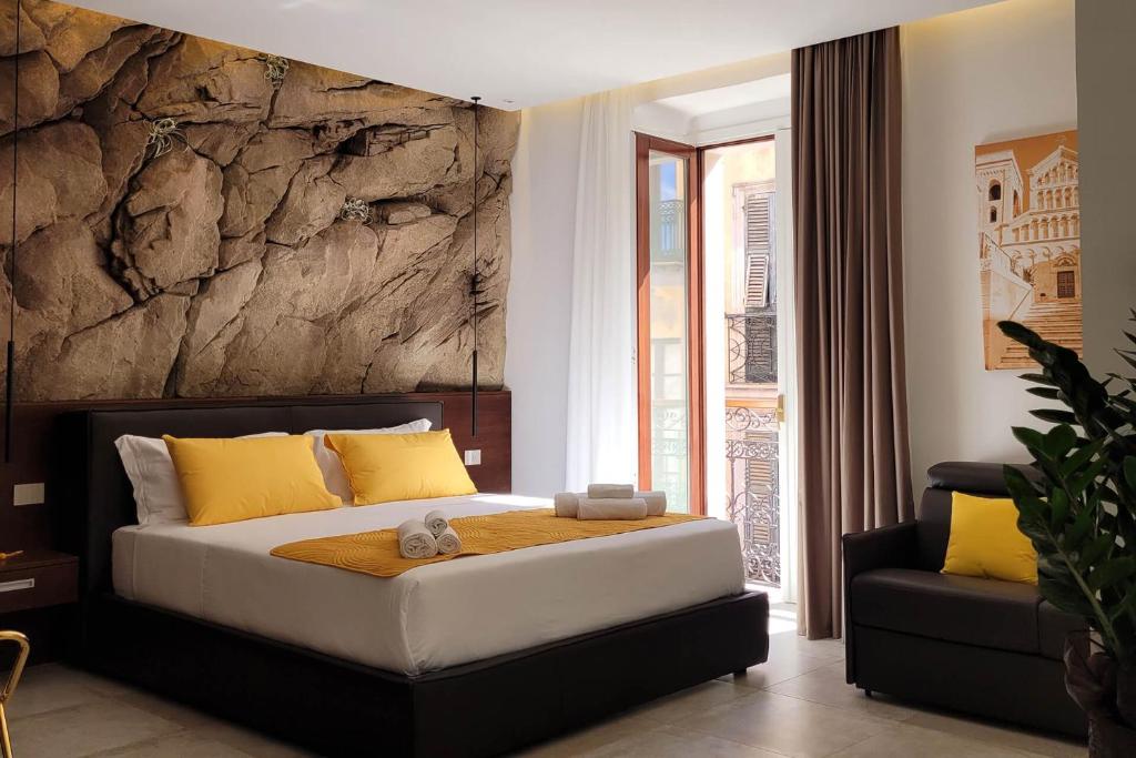 Palazzo Ferrucci Luxury Suites في كالياري: غرفة نوم بسرير كبير مع مخدات صفراء