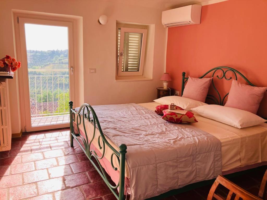 1 dormitorio con 1 cama grande y ventana en La Vite è Bella, en Govone