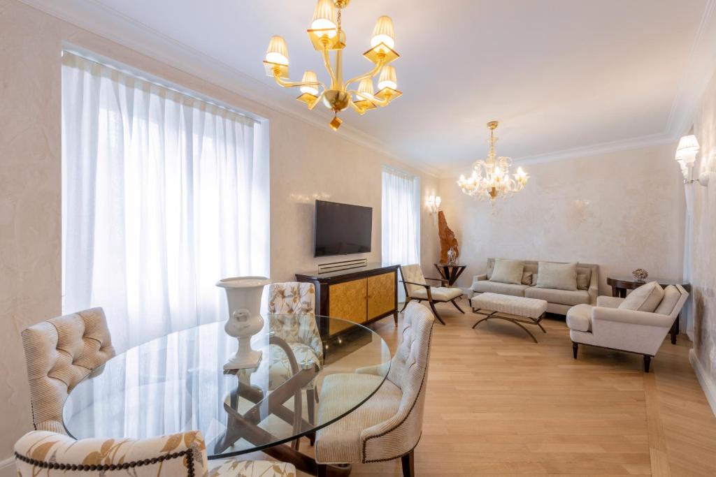 sala de estar con mesa de cristal y sillas en Milan Royal Suites - Centro Brera, en Milán