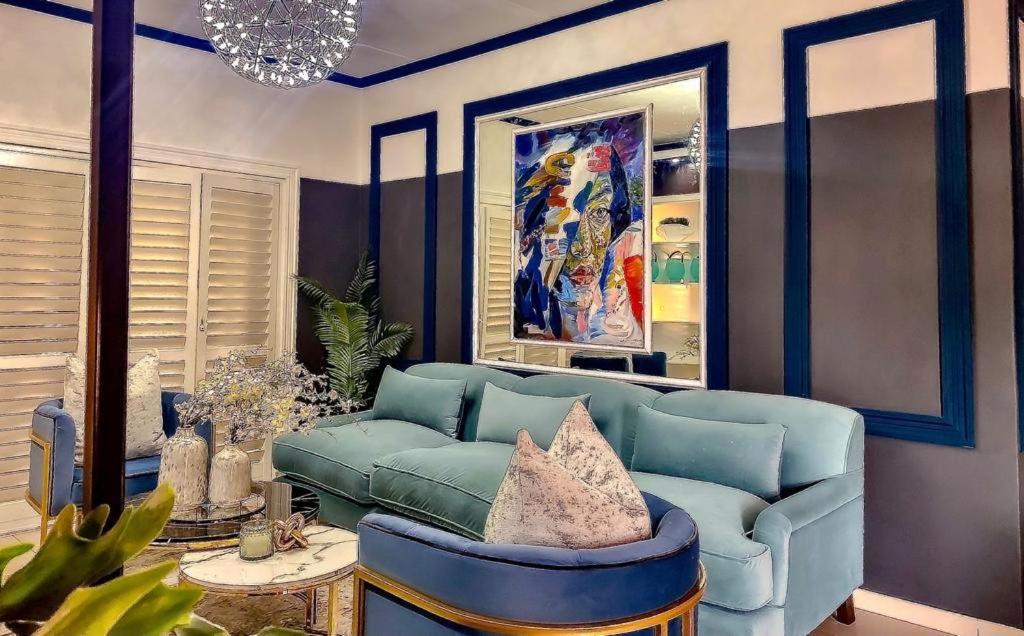 a living room with a blue couch and a table at Abusar Apartment in Boksburg