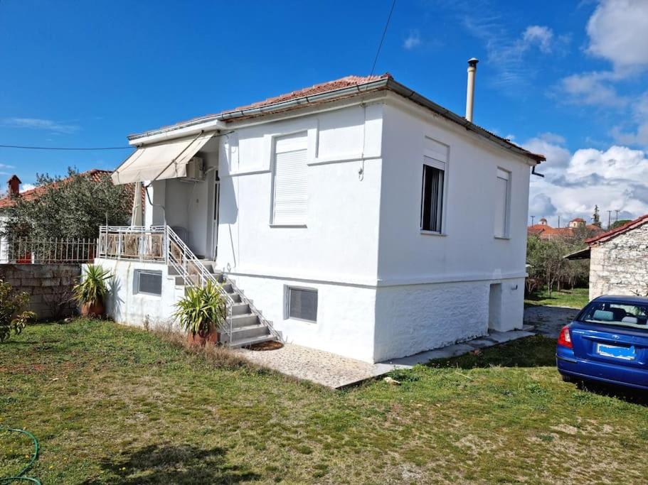 a white house with a car parked in front of it at Giannis country house in Palaiokómi