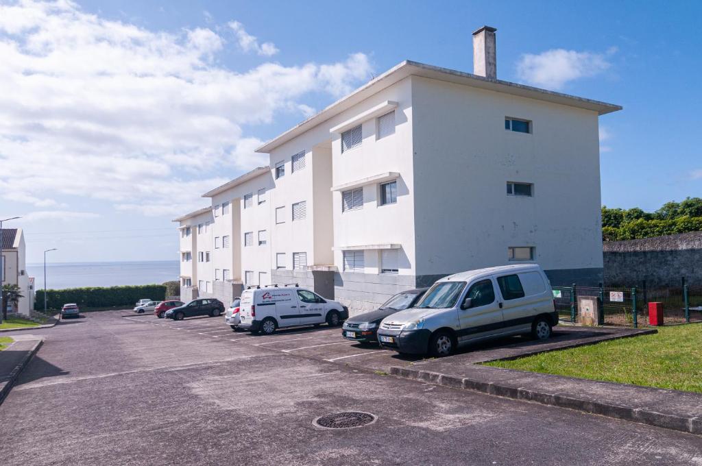 a parking lot with cars parked in front of a building at Island Jewel in Vila Franca do Campo