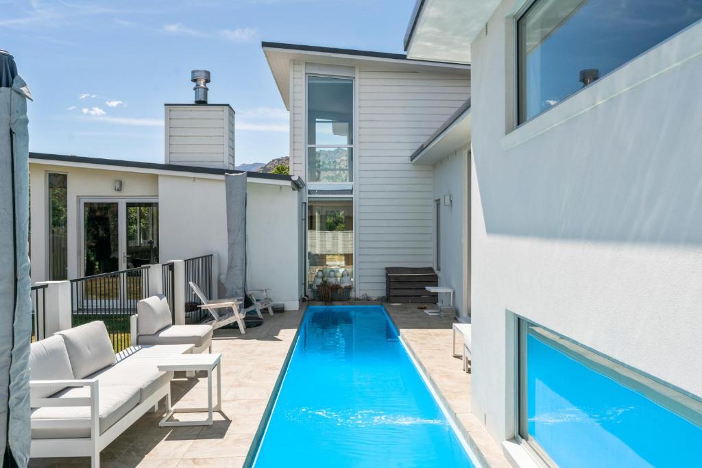 a swimming pool in the backyard of a house at Heavenly on Hope - Lake Hayes Holiday Home in Queenstown
