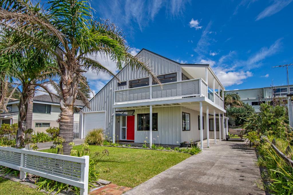 una casa con palmeras y una valla blanca en Retreat at Tapeka Point - Russell Holiday Home, en Russell