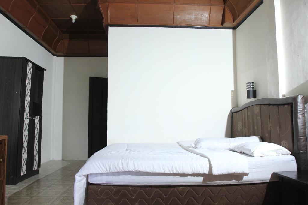 a bedroom with a large bed with white sheets at SONY COTTAGE in Tuk Tuk