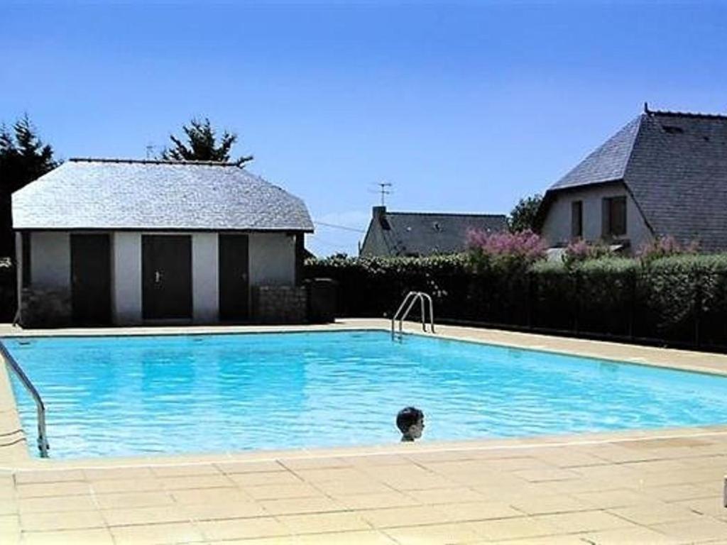 une grande piscine bleue devant une maison dans l'établissement Charmante Maison avec Piscine, Tennis, Proche Mer - Idéal Famille - FR-1-392-140, à Batz-sur-Mer