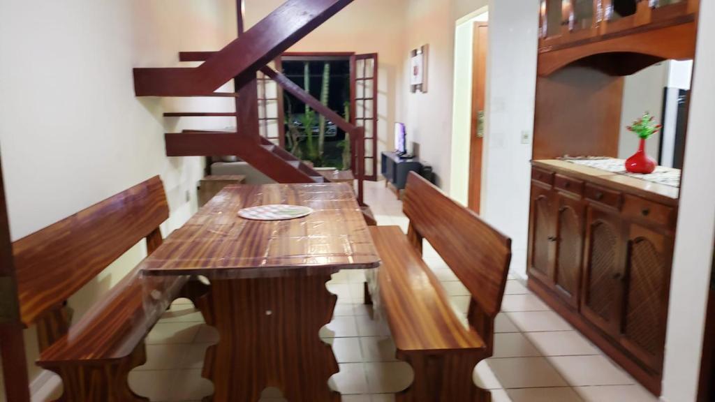 卡波布里奧的住宿－Casa maravilhosa，一间带木桌和楼梯的用餐室