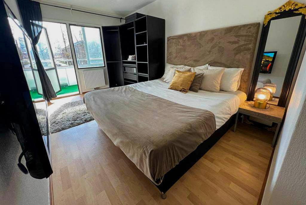 1 dormitorio con 1 cama grande en una habitación con ventanas en Private Room in Apartment en Malmö