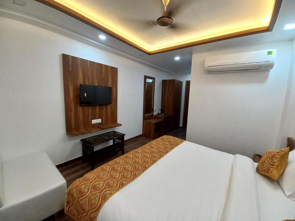a hotel room with a bed and a tv at Hotel The Rich Grand Agra in Agra