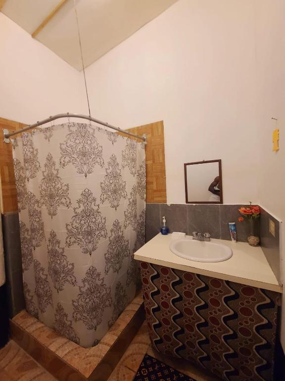 a bathroom with a sink and a shower at Drifters@One Mile in Negril