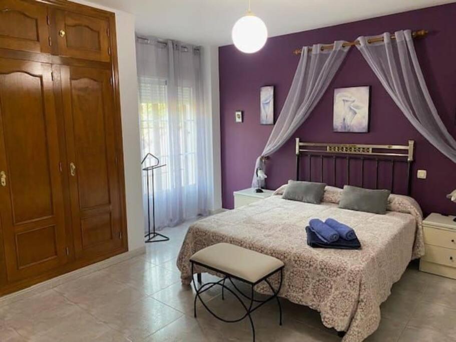 - une chambre violette avec un lit et une chaise dans l'établissement Vivienda Las Vistas, à Poyales del Hoyo