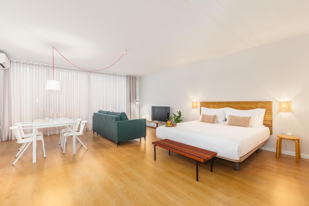 a hotel room with a bed and a dining room at Dream On - Clérigos Lofts in Porto