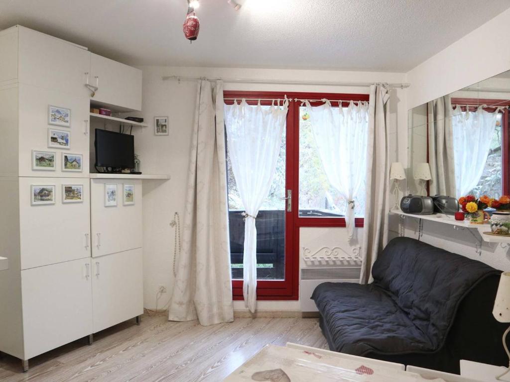 un soggiorno con divano e finestra di Appartement Les Orres, 1 pièce, 6 personnes - FR-1-322-403 a Les Orres
