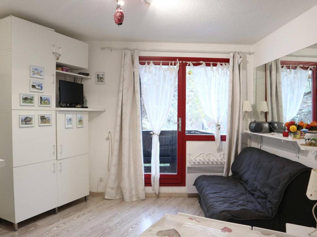 un salon avec un canapé et une fenêtre dans l'établissement Studio cosy 6 pers au pied des pistes, Les Orres - FR-1-322-403, aux Orres