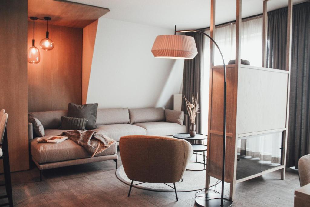 - un salon avec un canapé et une chaise dans l'établissement Appartementhotel Seeblick, à Gronau