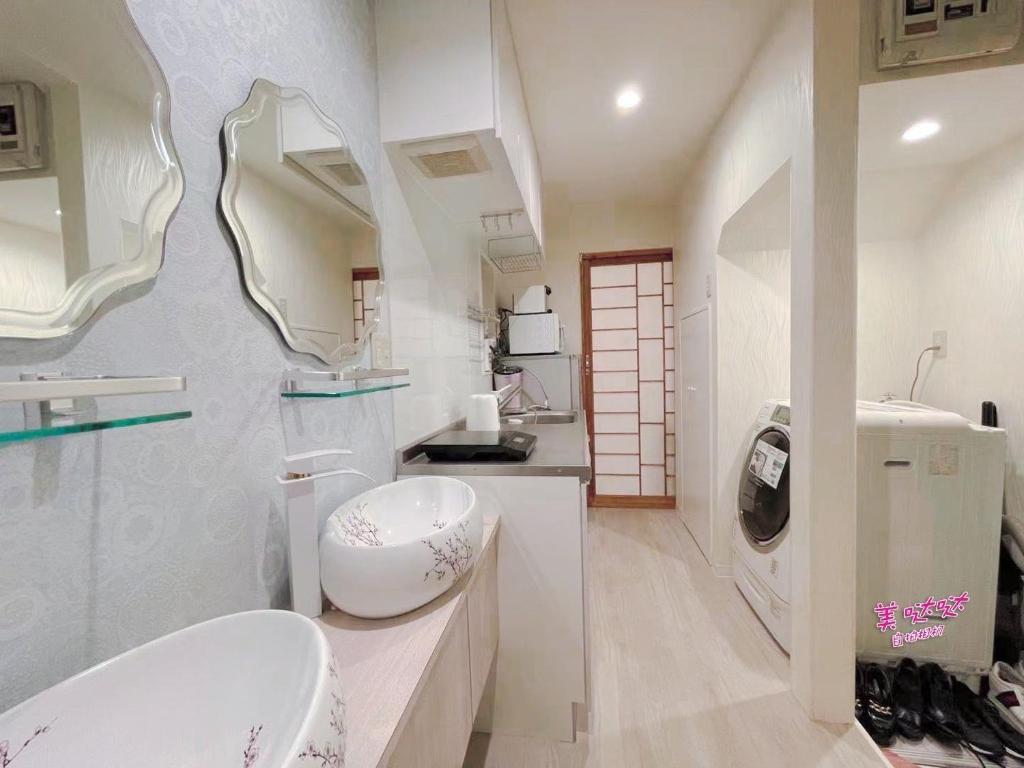 YUYUSO Hostel في طوكيو: حمام به مغسلتين ومرآة كبيرة