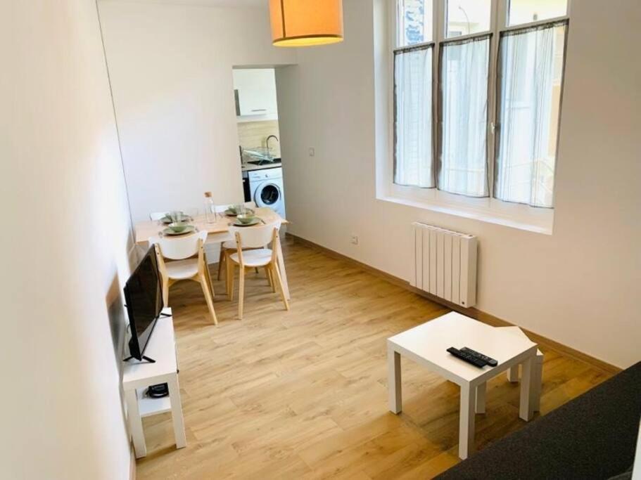 ein Wohnzimmer mit einem Tisch und einem Esszimmer in der Unterkunft Appartement plein centre in Paray-le-Monial