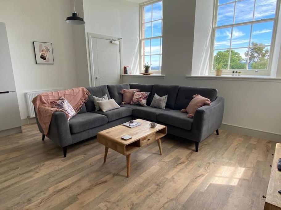 a living room with a couch and a coffee table at Premium apartment in a peaceful location with great views. in Inverness