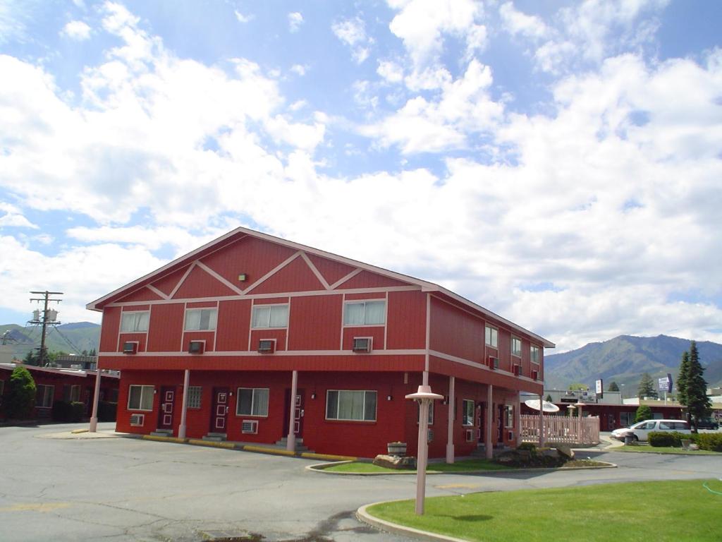 a red building in front of a parking lot at Avenue Motel Wenatchee in Wenatchee