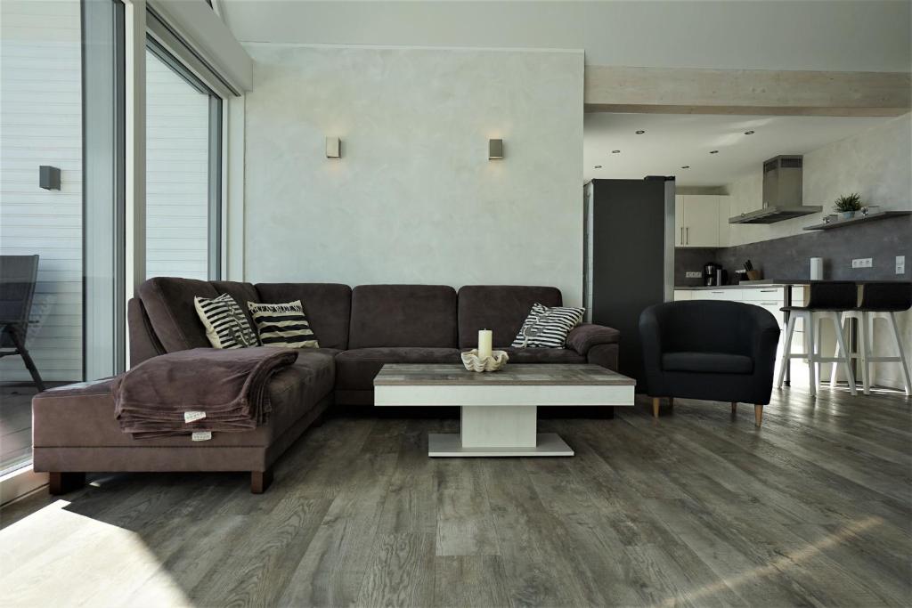 a living room with a brown couch and a table at Witte Bank in Büsum
