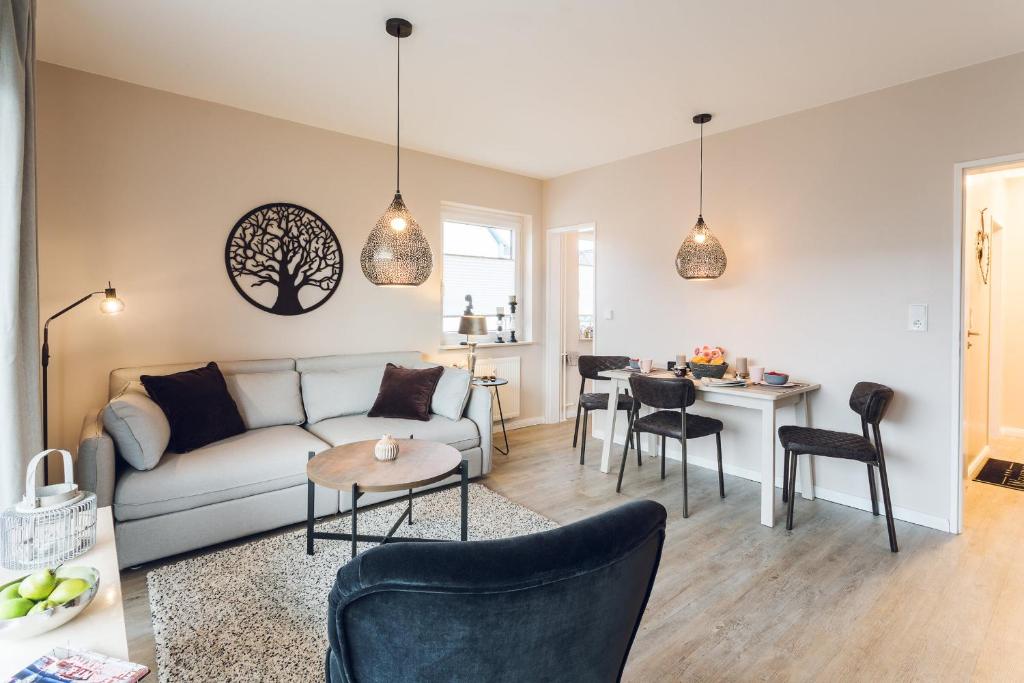 uma sala de estar com um sofá e uma mesa em Törn 33 em Büsum