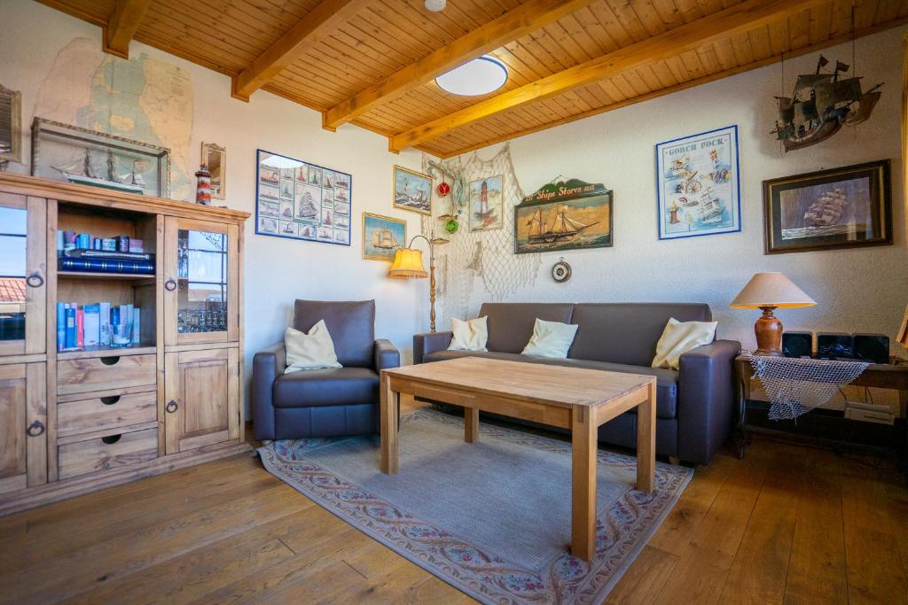 a living room with a couch and a table at Klaar Kimming Haus Wattwurm in Büsum