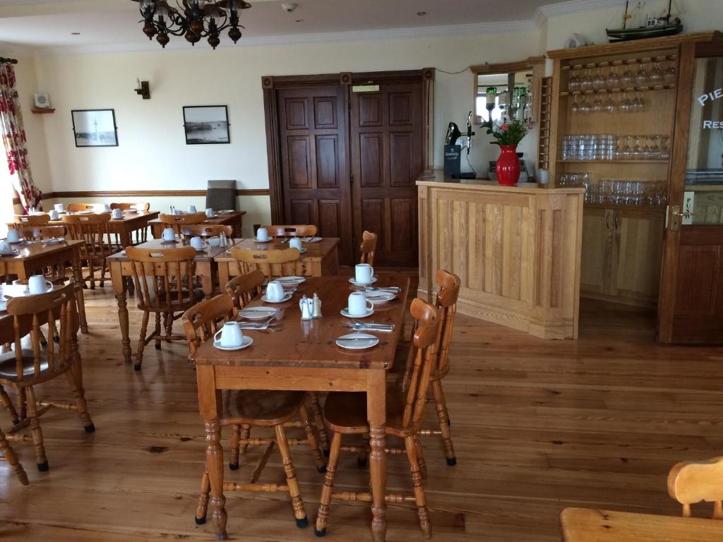 a dining room with wooden tables and chairs at Pier House Bed & Breakfast in Inis Mor