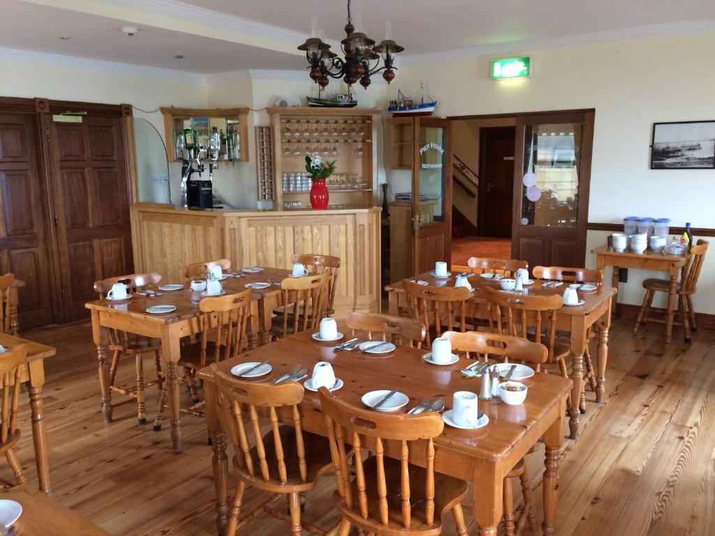 a dining room with wooden tables and chairs at Pier House Bed & Breakfast in Inis Mor