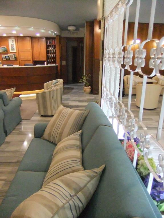 a living room with a blue couch and chairs at Hotel Giulio Cesare in Cinquale