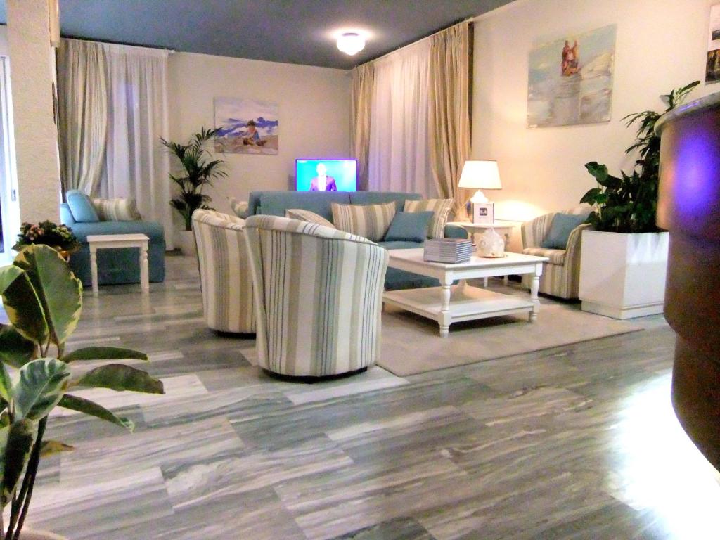 a living room with a couch and chairs and a table at Hotel Giulio Cesare in Cinquale