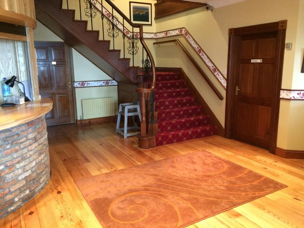 a staircase in a house with a red carpet at Pier House Bed & Breakfast in Inis Mor