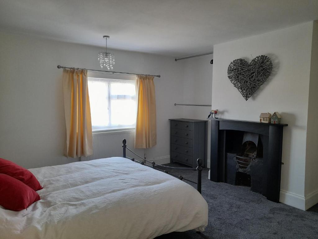 a bedroom with a bed and a fireplace with a heart on the wall at The Little House Louth in Louth