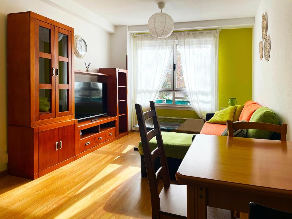 A television and/or entertainment centre at Piso moderno en la playa Gijón
