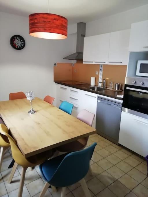 une cuisine avec une table et des chaises en bois dans l'établissement Maison Monts d’Arree 3 chambres, à Sizun