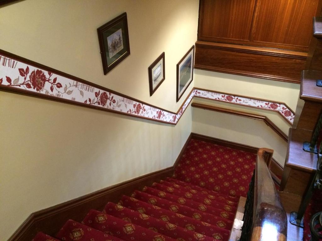a staircase with a red couch in a building at Pier House Bed & Breakfast in Inis Mor