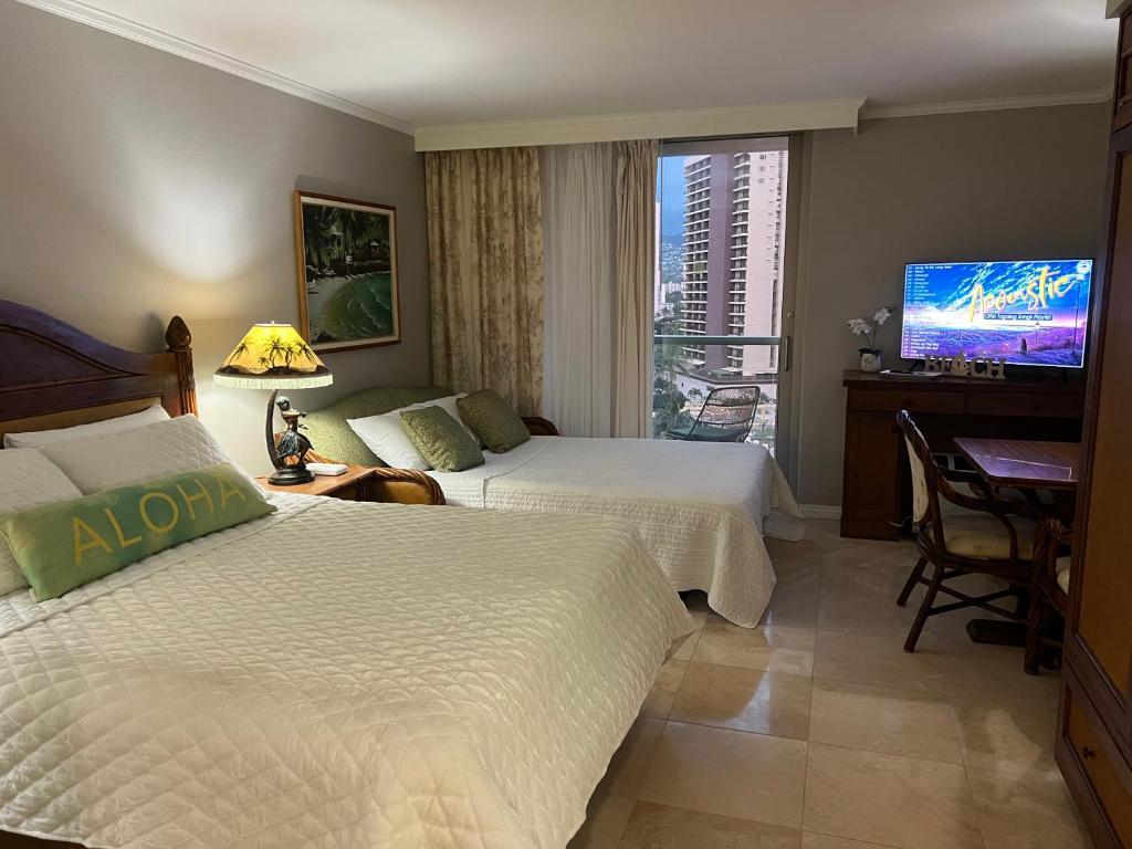 a hotel room with two beds and a flat screen tv at Aloha Gem Studio - 2 bed with high speed WIFI - Luana Waikiki Hotel & Suite 917, 2045 Kalakaua Avenue HI 96815 in Honolulu