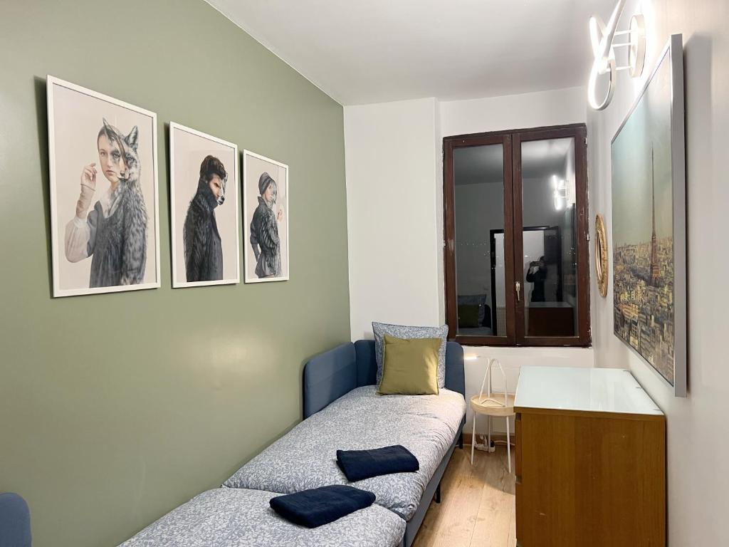 une chambre avec un canapé et des photos sur le mur dans l'établissement 016 CHIC & COSY GRAND APPART MODERNE 65m2 HYPERCENTRE WIFI SMART TV NETFLIX, à Saint-Étienne