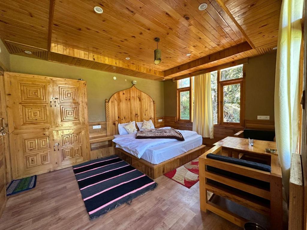 a bedroom with a bed and a wooden ceiling at The Village View Homestay in Jibhi